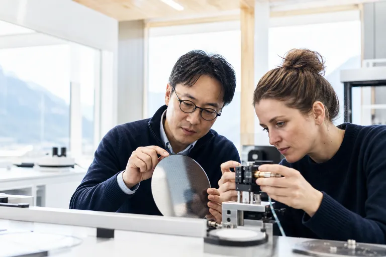 Deux ingénieurs inspectent un wafer et règlent un module photonique.