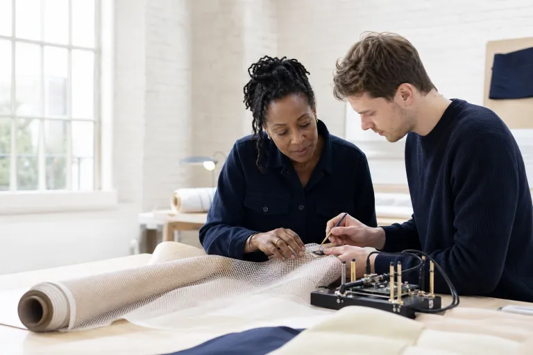 Deux ingénieurs intègrent un capteur dans un textile technique.
